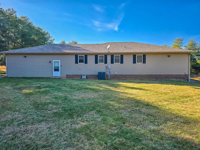 rear view of property with a yard and central AC unit