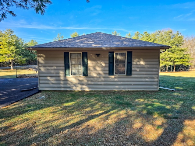 view of side of home with a yard