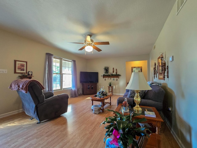 living room with ceiling fan and light hardwood / wood-style flooring