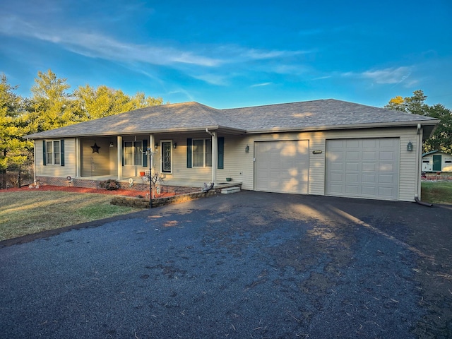 single story home featuring a garage, a front yard, and covered porch