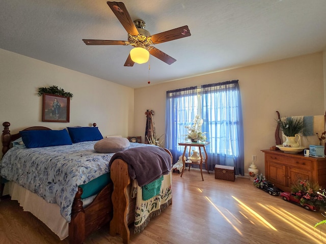 bedroom with ceiling fan and light hardwood / wood-style floors