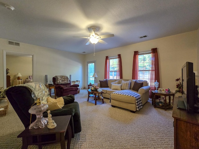 carpeted living room featuring a textured ceiling and ceiling fan