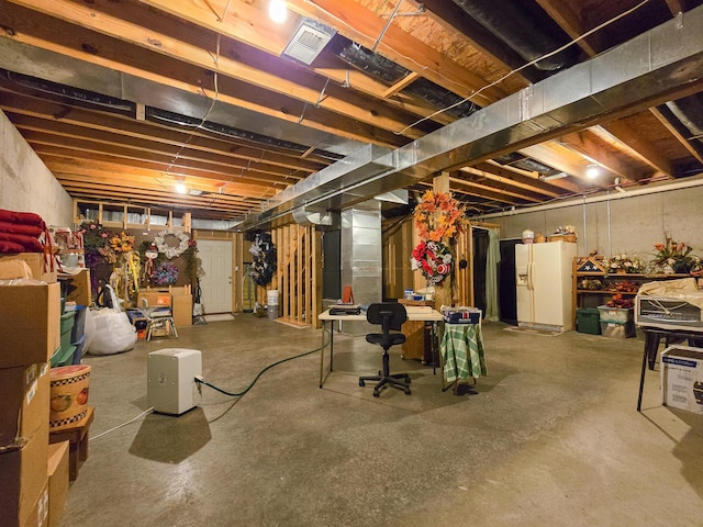 basement featuring white refrigerator with ice dispenser