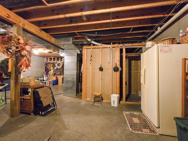 basement with white refrigerator with ice dispenser