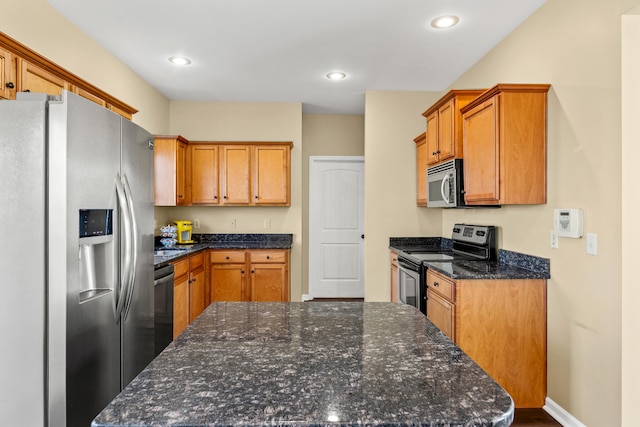 kitchen featuring appliances with stainless steel finishes and dark stone counters