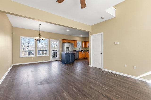 unfurnished living room with dark wood-type flooring and ceiling fan with notable chandelier