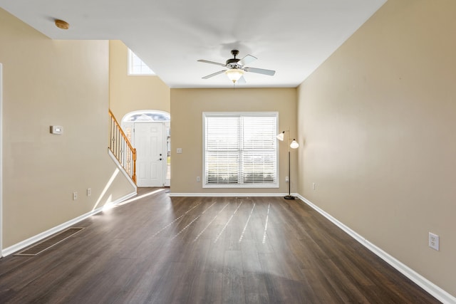 unfurnished living room featuring ceiling fan and dark wood-type flooring