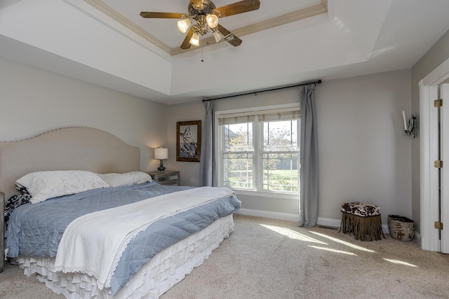 carpeted bedroom with crown molding, ceiling fan, and a raised ceiling