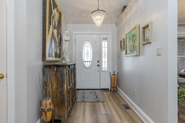 foyer entrance with a chandelier and light hardwood / wood-style flooring