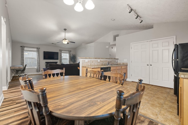 dining room with sink, vaulted ceiling, and ceiling fan