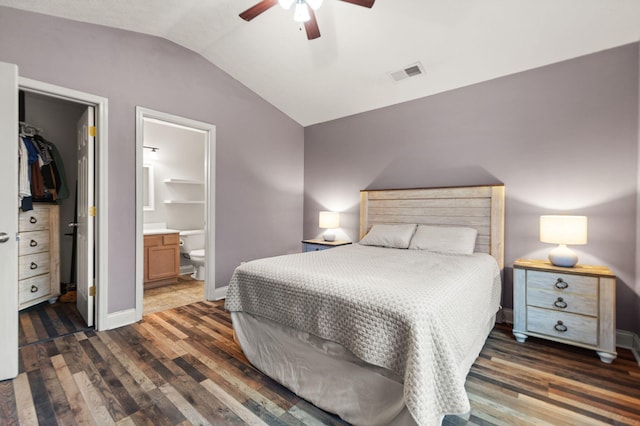 bedroom featuring a walk in closet, vaulted ceiling, dark hardwood / wood-style floors, and ceiling fan