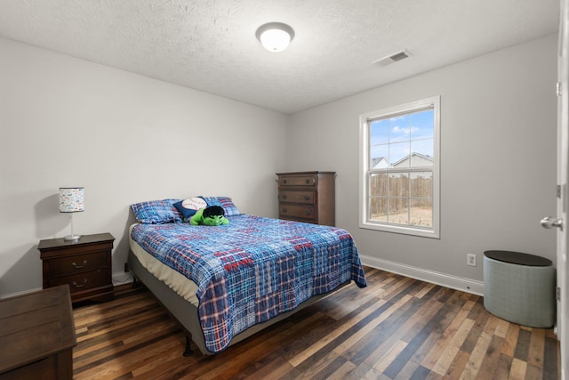 bedroom with dark wood-type flooring and a textured ceiling