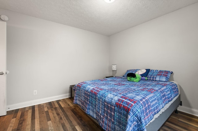 bedroom featuring dark wood-type flooring and a textured ceiling