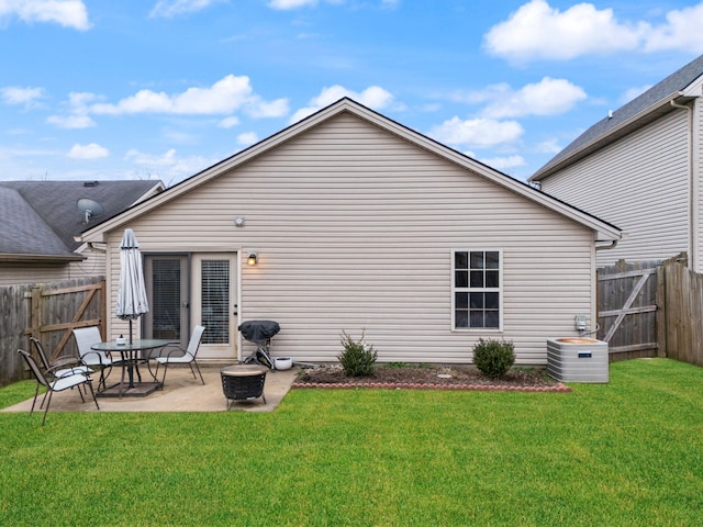 back of house featuring a yard, a fire pit, a patio, and central AC unit