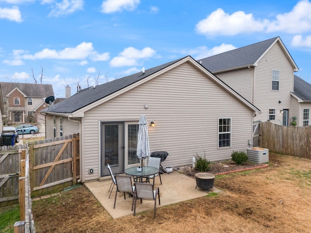 rear view of house with central AC, a patio, and an outdoor fire pit