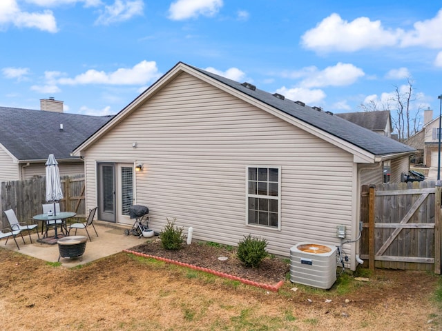 rear view of house with central AC unit and a patio