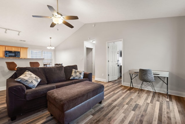 living room with dark wood-type flooring, lofted ceiling, and ceiling fan with notable chandelier