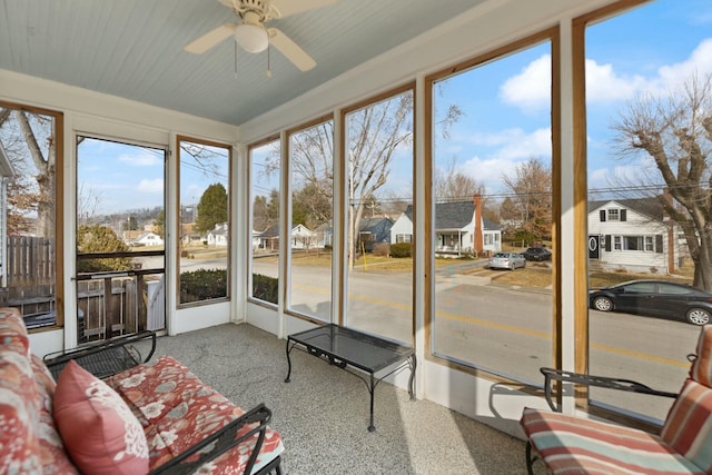 sunroom / solarium with ceiling fan and a residential view