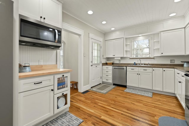 kitchen featuring stainless steel appliances, white cabinets, a sink, and open shelves