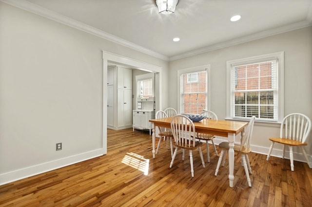 dining room featuring recessed lighting, crown molding, light wood finished floors, and baseboards