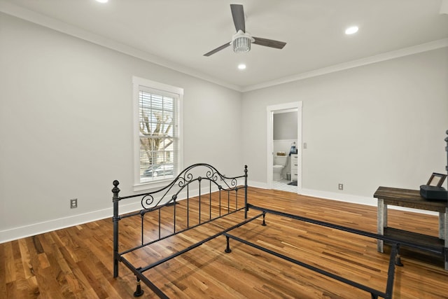 bedroom with ornamental molding, wood finished floors, and baseboards