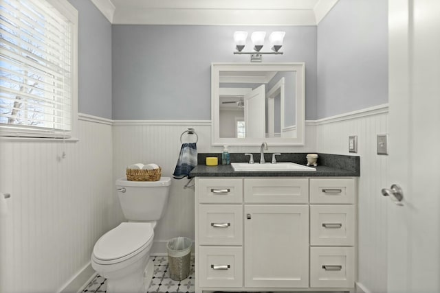 half bath featuring toilet, a wainscoted wall, and vanity