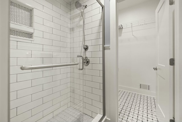 full bath with a shower stall, visible vents, and a walk in closet