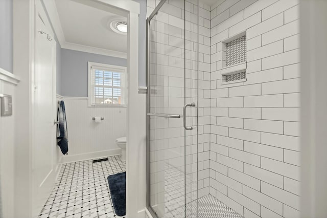 bathroom with a wainscoted wall, crown molding, visible vents, toilet, and a shower stall