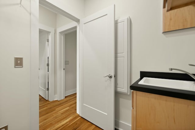 interior space with light wood-style floors and a sink