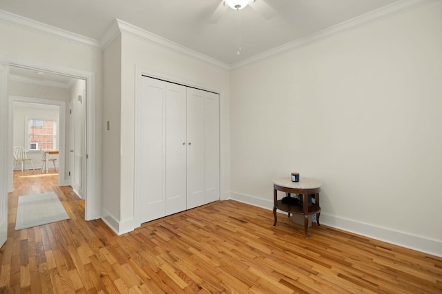 unfurnished bedroom featuring light wood finished floors, a closet, ornamental molding, a ceiling fan, and baseboards