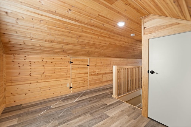 additional living space with lofted ceiling, wood walls, wood ceiling, and wood finished floors