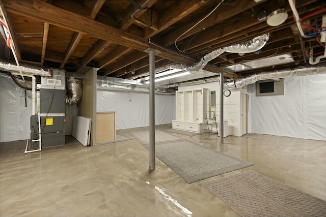 unfinished basement featuring heating unit