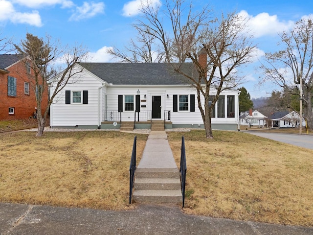 view of front of house with a shingled roof, a front yard, crawl space, and a chimney