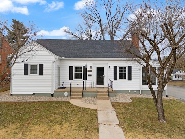 view of front facade with a chimney, a front lawn, crawl space, and a shingled roof