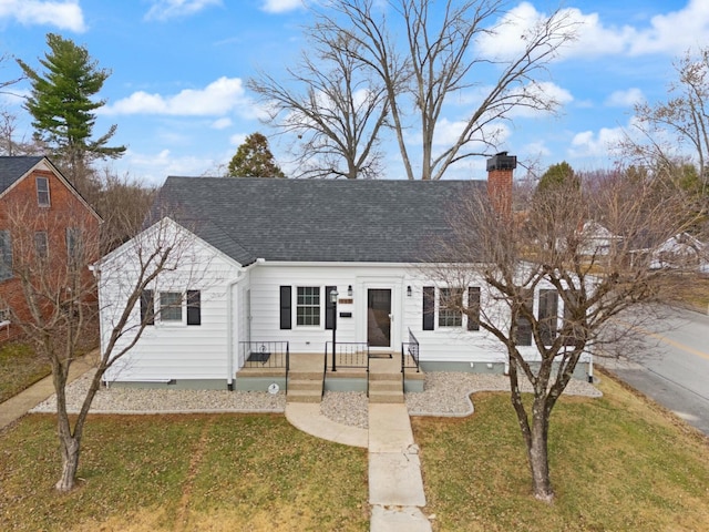 view of front of house with roof with shingles, a front lawn, a chimney, and crawl space