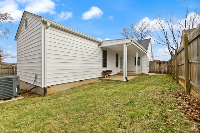 view of side of home featuring a lawn, a fenced backyard, crawl space, cooling unit, and a patio area