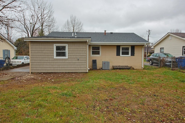 back of property with a yard and central air condition unit