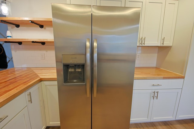 kitchen featuring wood counters, stainless steel fridge with ice dispenser, tasteful backsplash, and white cabinets