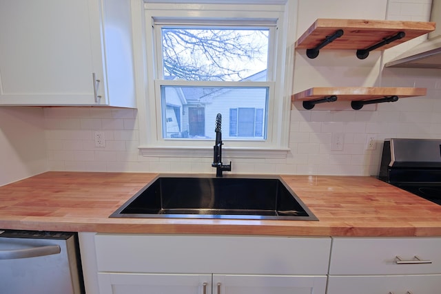 kitchen featuring white cabinetry, sink, wooden counters, and appliances with stainless steel finishes