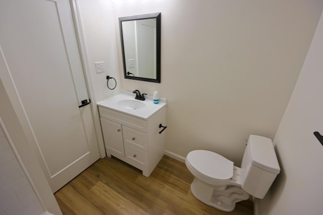 bathroom featuring vanity, toilet, and hardwood / wood-style floors