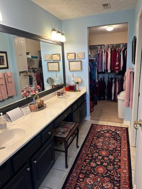 bathroom with tile patterned floors, a textured ceiling, and vanity