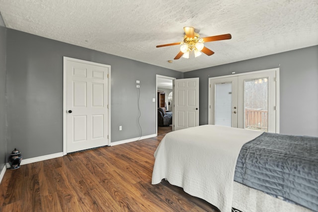 bedroom featuring dark hardwood / wood-style floors, access to outside, ceiling fan, a textured ceiling, and french doors