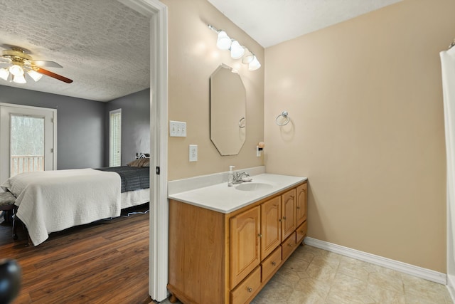 bathroom with vanity, a textured ceiling, and ceiling fan