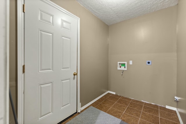 washroom featuring hookup for a washing machine, dark tile patterned floors, hookup for an electric dryer, and a textured ceiling