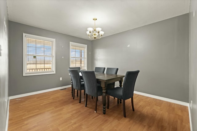 dining room featuring light wood-type flooring and a notable chandelier