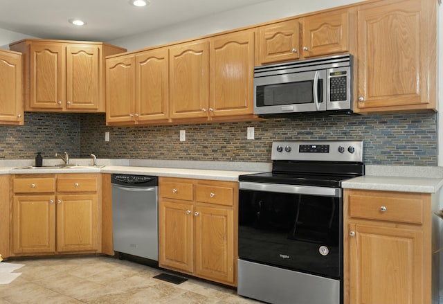 kitchen with backsplash, sink, and appliances with stainless steel finishes