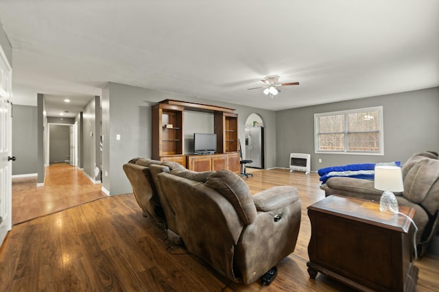 living room featuring ceiling fan, wood-type flooring, and heating unit