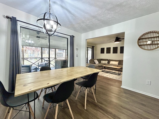 dining space with hardwood / wood-style flooring, ceiling fan with notable chandelier, and a textured ceiling