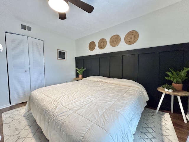 bedroom with light wood-type flooring, ceiling fan, and a closet