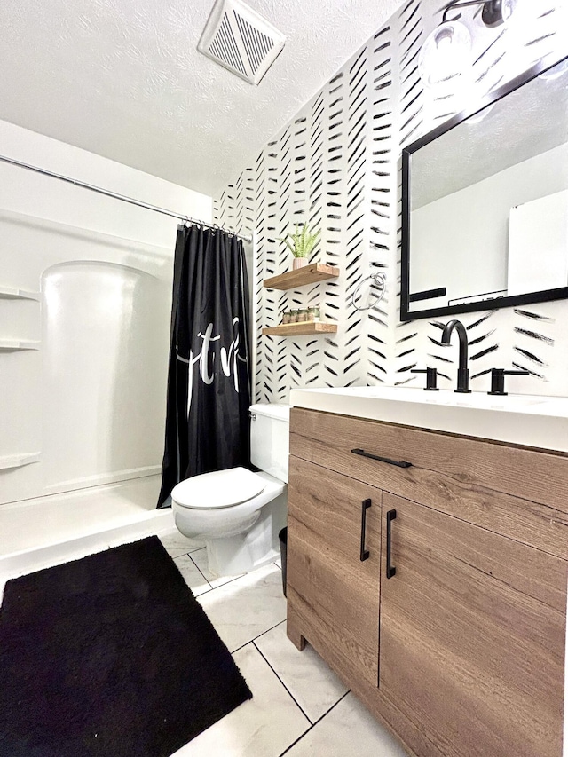 bathroom featuring vanity, a textured ceiling, toilet, and walk in shower